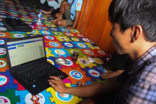 Seorang kader database sedang menjelaskan sistem database desa.